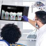 A dentist talks a patient through an AI image of their dental issue.