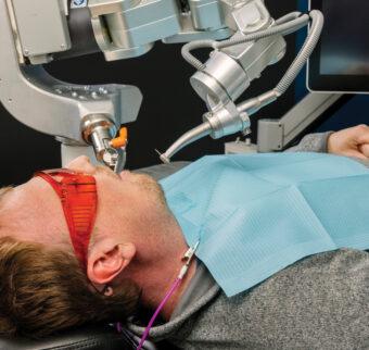 A patient lies back while the robot dentist performs the procedure