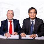 Paddy Bolger (left) with Professor Albert Leung signing contracts.